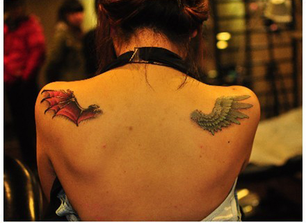 女生肩背时尚的一半天使与一半恶魔的翅膀纹身图案